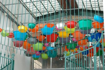Low angle view of colorful baskets hanging from ceiling