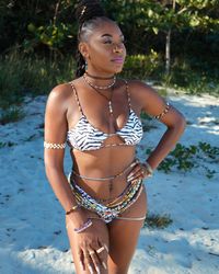 Portrait of young woman in bikini standing in lake