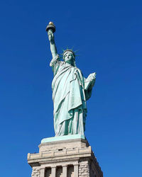 Low angle view of statue against blue sky