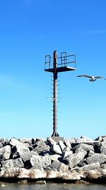 Low angle view of windmill against clear blue sky