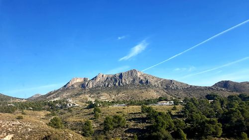 Scenic view of mountains against blue sky