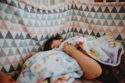 High angle view of baby sleeping on bed at home