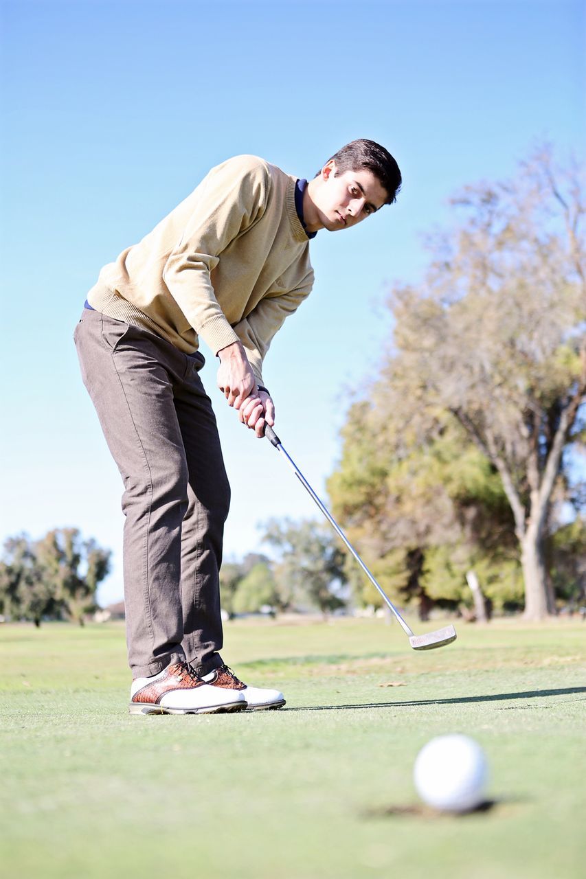 MIDSECTION OF MAN PLAYING WITH BALL ON FIELD