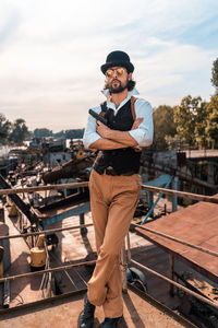 Portrait of young man standing against railing