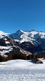 Scenic view of snowcapped mountains against clear blue sky