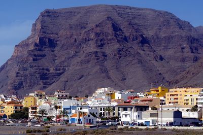 Buildings in town against mountain range