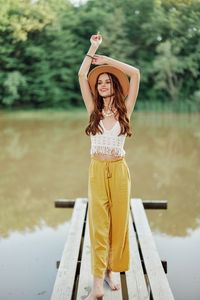 Portrait of young woman standing against sea