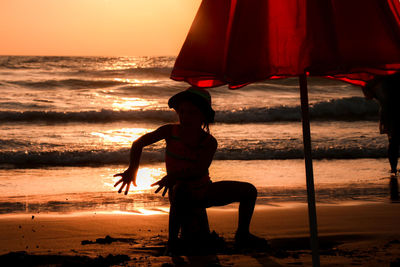 Full length of man standing on beach during sunset