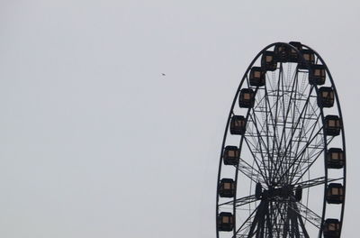 Low angle view of ferris wheel against clear sky