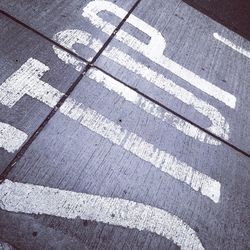 High angle view of stop text on footpath