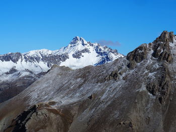 Scenic view of snowcapped mountains against clear blue sky