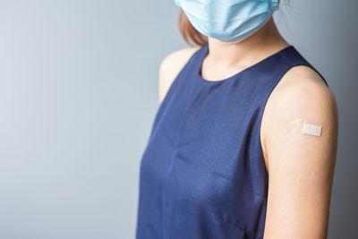 Midsection of woman standing against white background