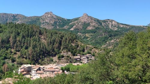 Scenic view of mountains and houses against sky