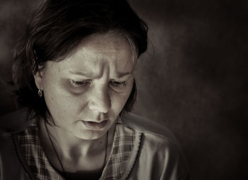 Close-up of tensed woman against wall