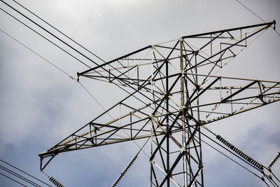 Low angle view of electricity pylon against sky