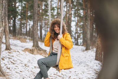 Woman smiling in snow covered forest