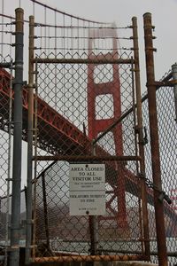 Low angle view of text on metal against sky