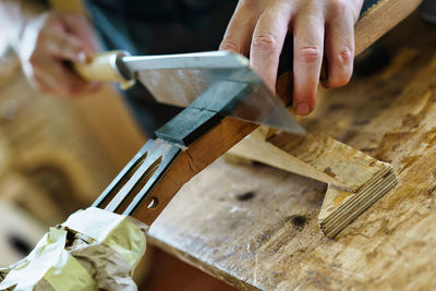 Cropped hand of man working on wood