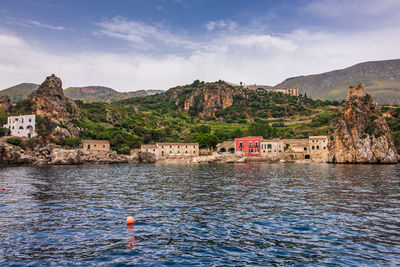 Scenic view of sea and buildings against sky