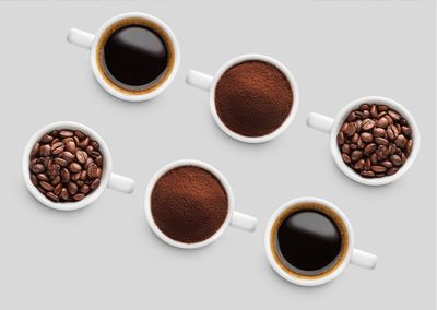 High angle view of roasted coffee beans against white background