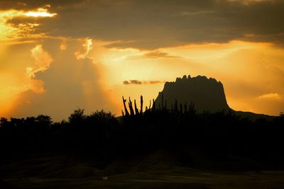 Scenic view of silhouette mountains against orange sky