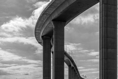 Low angle view of bridge against cloudy sky