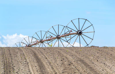 Low angle view of windmill on field against sky