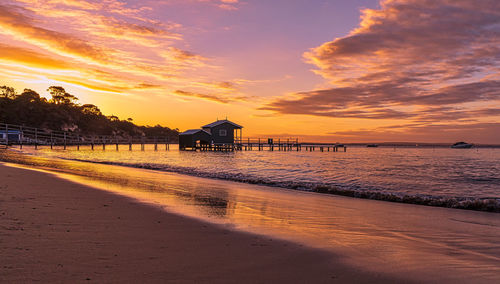 Pier over sea against sky during sunset