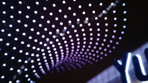 Low angle view of illuminated lights against blue sky