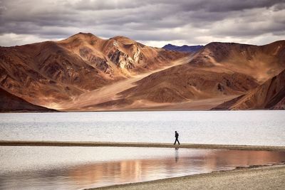 Scenic view of lake by mountains against sky