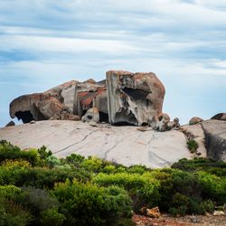 Rock formations on landscape against cloudy sky