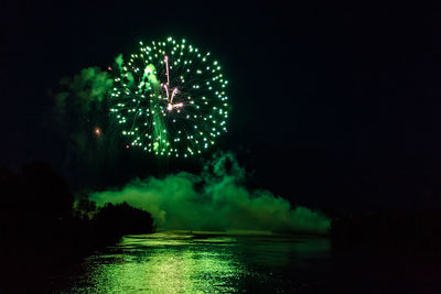 Firework display over river at night