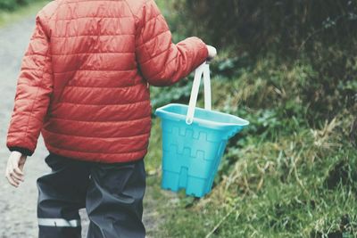 Midsection of boy holding bucket