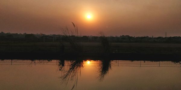 Reflection of sun in lake during sunset
