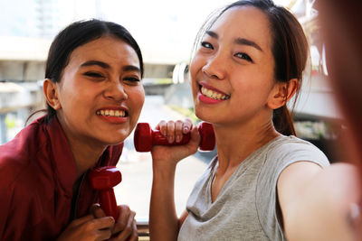 Portrait of a smiling young woman holding camera