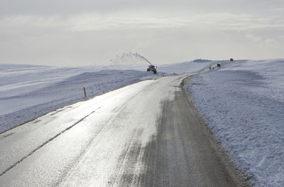 Scenic view of road by sea against sky