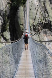 Rear view of friends walking on footbridge