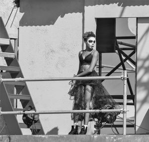 Portrait of woman standing against wall