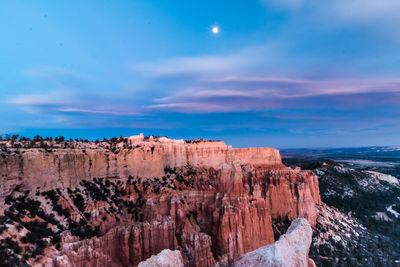 Rock formations on landscape against cloudy sky