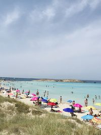 People on beach against sky