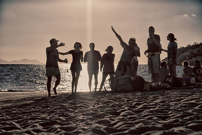 People at beach against sky