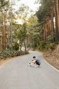 Man sitting on road in forest