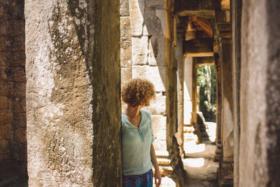 Rear view of woman standing at historic building