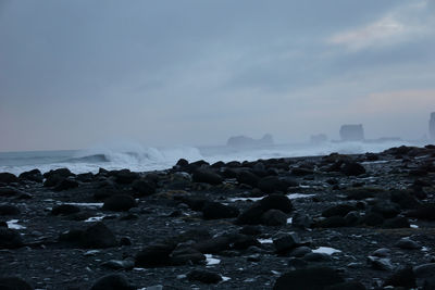Rocks on beach against sky