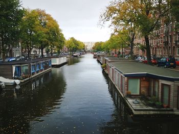 Canal in city against sky