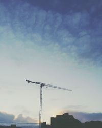 Low angle view of crane against sky