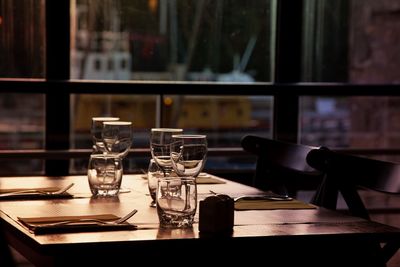 Glasses and forks on table by window