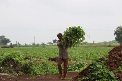 Labour farmer man standing on field against sky.