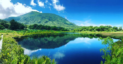 Scenic view of lake and mountains against blue sky