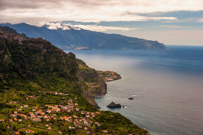 High angle view of sea and mountains against sky